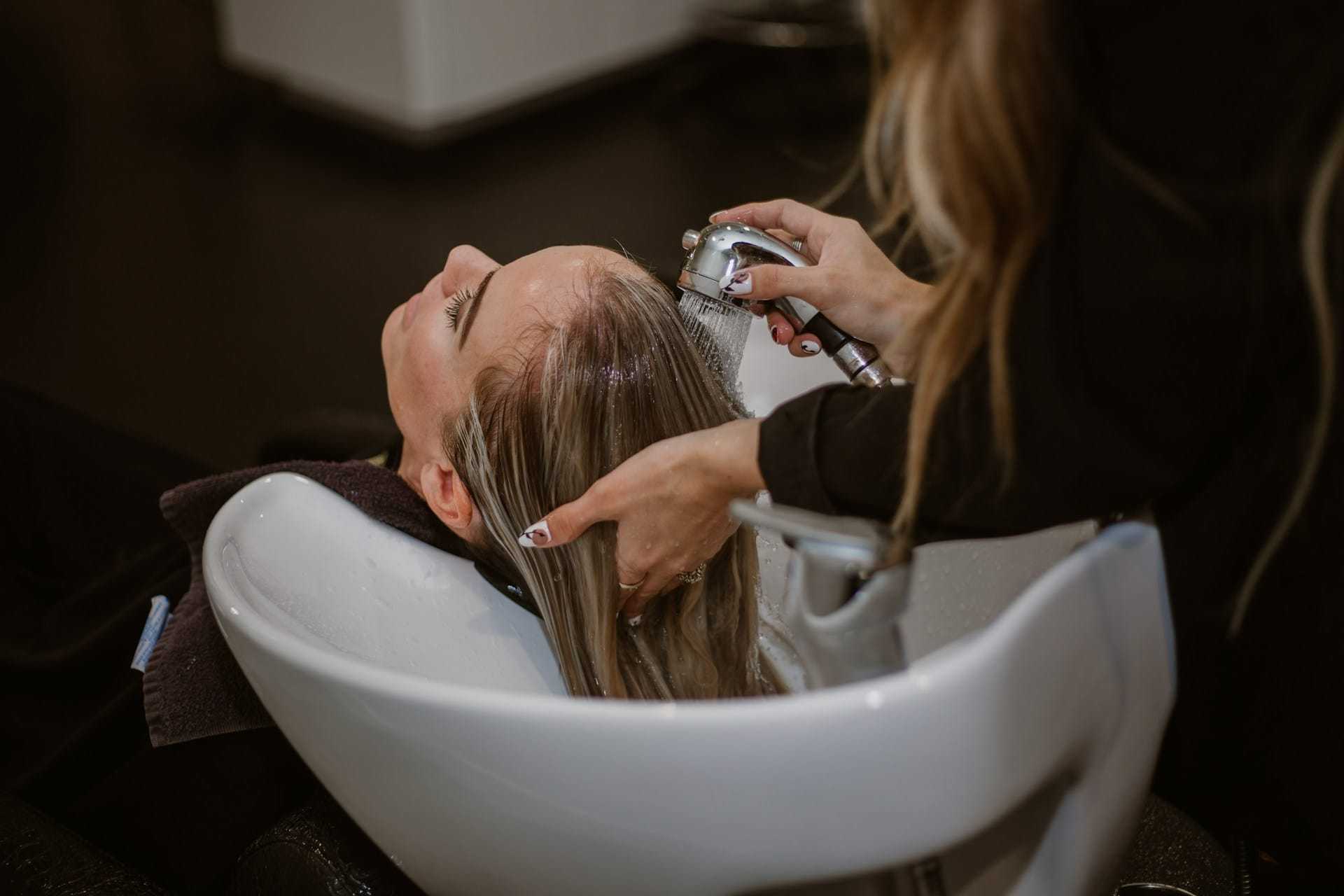 Person getting their hair washed at a salon sink.